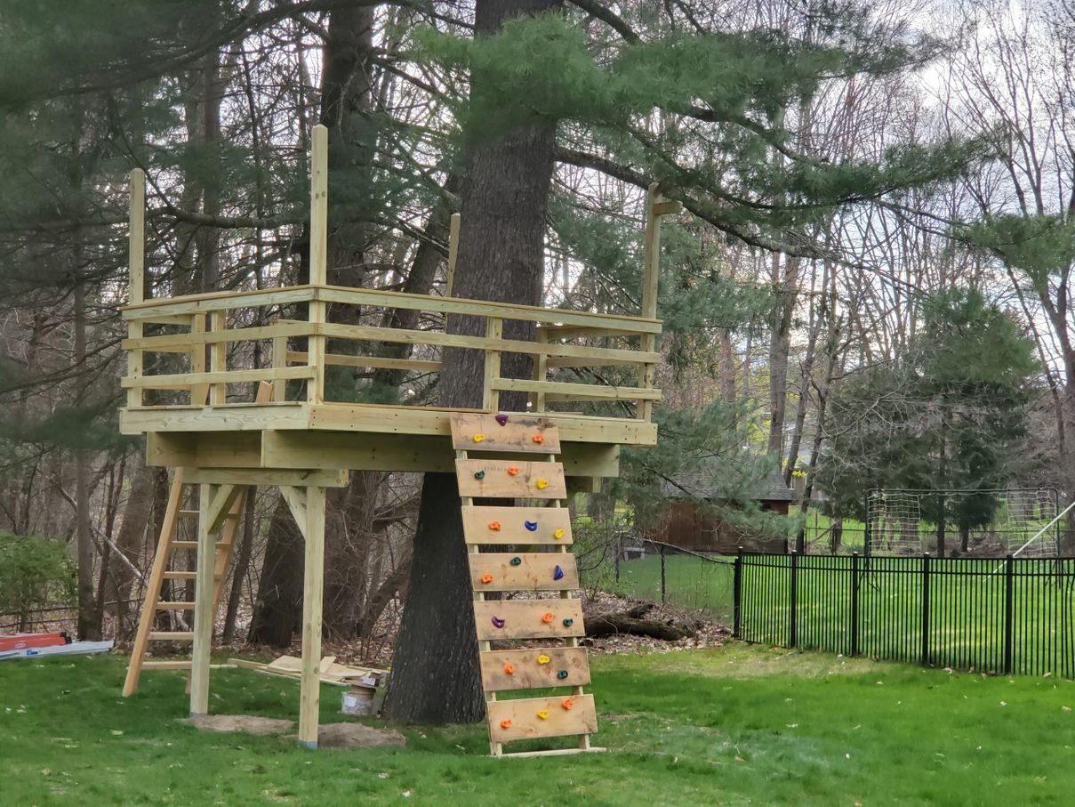 Double platform treehouse deck with rock walls and bridge