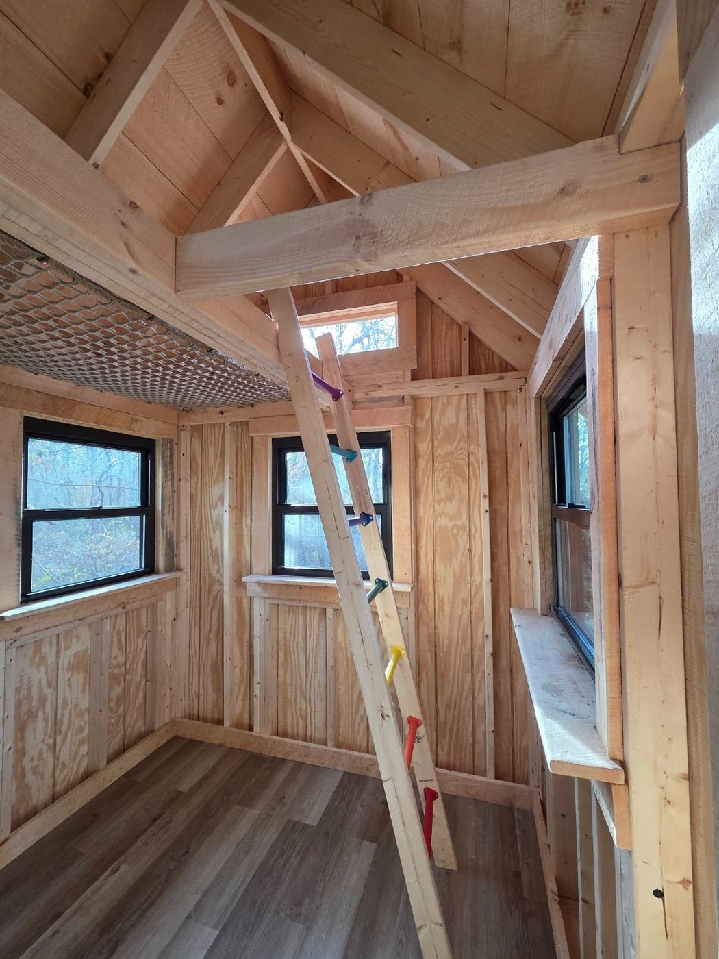 Finished treehouse interior with reversed T1-11 walls and laminate floor