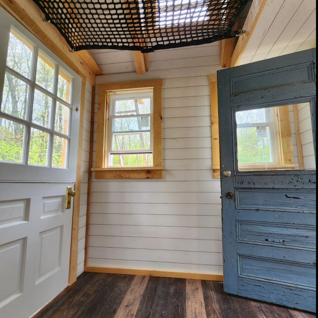 Finished treehouse interior with loft net and painted door
