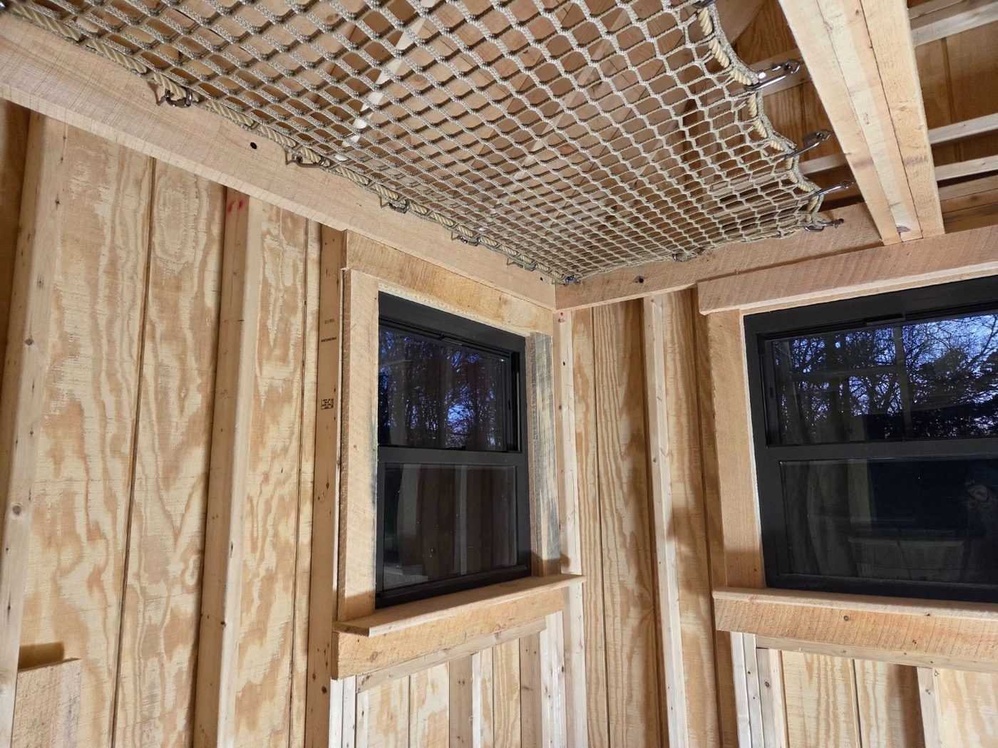 Interior treehouse loft net installed under wood framing