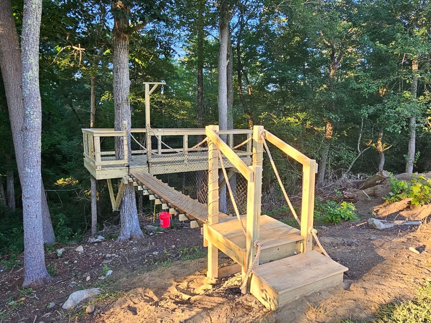 Multi-tree elevated deck with bridge structure in the woods
