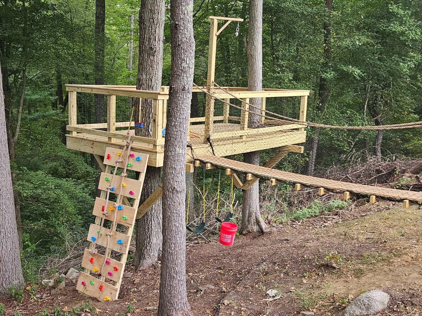 Two-platform treehouse build with bridge and rock climbing wall